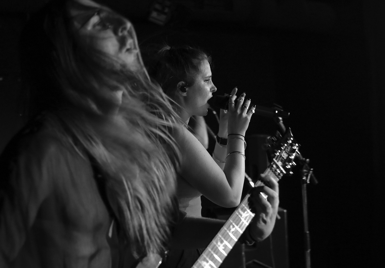 Singer and guitarist mid-song on a dark stage
